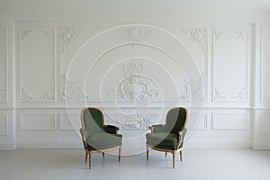 Luxury clean bright white interior with a old antique vintage green chairs over wall design bas-relief stucco mouldings