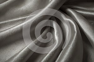 luxury cloth with drapery and wavy folds of ivory color creased smooth silk satin material texture. Abstract