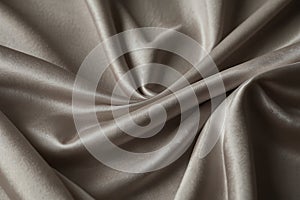 luxury cloth with drapery and wavy folds of ivory color creased smooth silk satin material texture. Abstract