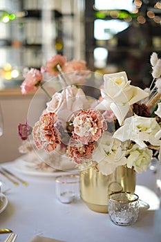 Luxury cozy autumn wedding table decoration in the restaurant. Fresh and dried flowers, roses, carnations. Beautiful table setting