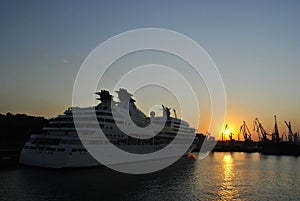 Luxury cruise ship sailing to port on sunrise