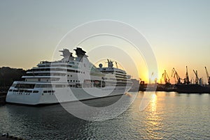 Luxury cruise ship sailing to port on sunrise