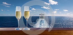 Luxury cruise travel with glasses of champagne on wooden railing.