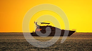 Luxury cruise trip. Red burning sunset over the sea with silhouette of rich yacht. Abstract nature summer ocean sea