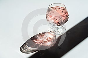 Luxury crystal glass with shampagne and its shade on a white tab