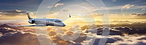 Luxury design private jet flying over the clouds in the sky at sunset. Travel background and wide aerial banner