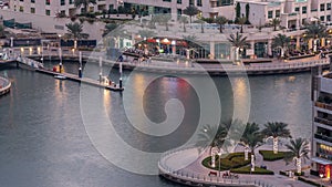 Luxury Dubai Marina canal with passing boats and promenade day to night timelapse, Dubai, United Arab Emirates