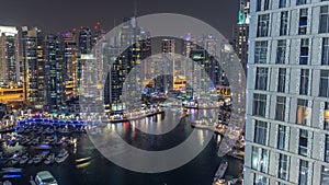 Luxury Dubai Marina canal with passing boats and promenade night timelapse, Dubai, United Arab Emirates