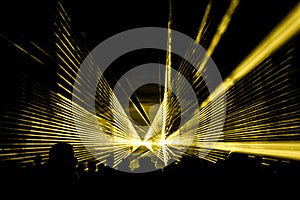 Yellow laser show nightlife club stage with party people crowd