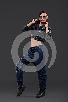 Luxury Fashion model, a beautiful woman posing in studio on gray background with glasses from the sun.