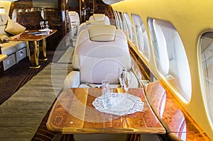 Luxury genuine leather interior in a modern business jet. There are several glasses on the table