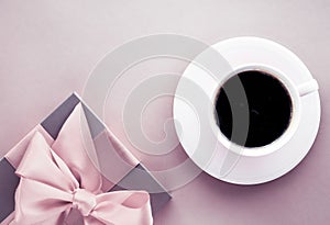 Luxury gift box and coffee cup on blush pink background, flatlay design for romantic holiday and birthday surprise