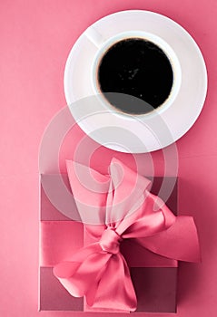 Luxury gift box and coffee cup on pink background, flatlay design for romantic holiday morning surprise