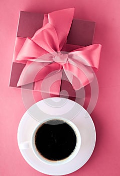 Luxury gift box and coffee cup on pink background, flatlay design for romantic holiday morning surprise