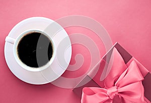 Luxury gift box and coffee cup on pink background, flatlay design for romantic holiday morning surprise