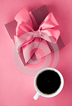 Luxury gift box and coffee cup on pink background, flatlay design for romantic holiday morning surprise