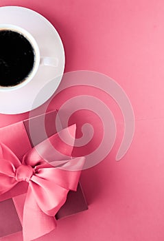 Luxury gift box and coffee cup on pink background, flatlay design for romantic holiday morning surprise