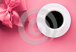 Luxury gift box and coffee cup on pink background, flatlay design for romantic holiday morning surprise