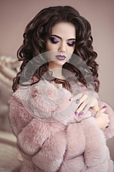 Luxury girl in pink fur coat. Beauty makeup. Brunette with long