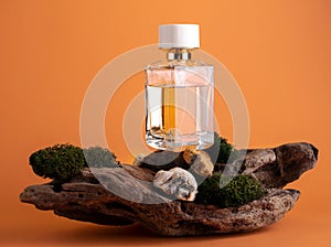 Luxury glass perfume bottle on  wooden product sand with moss orange background