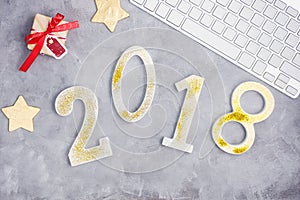 Luxury glitter numbers 2018 with keyboard and presents on grey concrete background