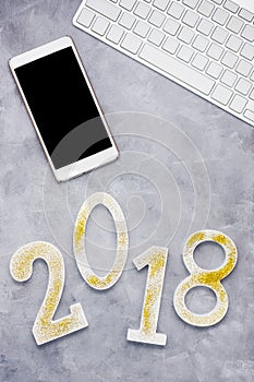 Luxury glowing numbers 2018 with cell phone and keyboard on grey background