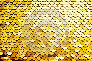 Luxury golden Background. Abstract Texture scales with gold Sequins close-up. Glamor Background with shiny Sequins on fabric,