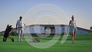 Luxury golfers enjoy play on fairway outdoors. Sport group stand on green course