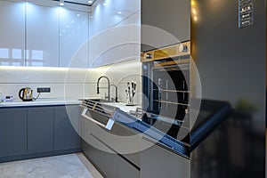 Luxury gray modern kitchen interior, oven's door opened