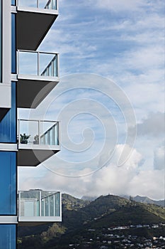 Luxury high-rise apartment building balconies overlooking green forest mountains