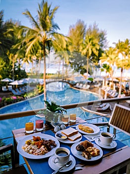 Luxury hotel with breakfast table and a look at the swimming pool and ocean in Thailand