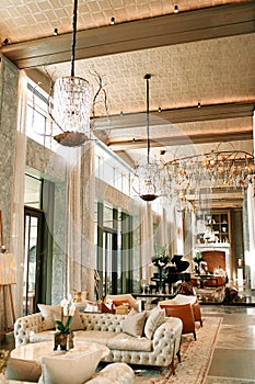 Luxury hotel foyer with sofas, tables and stylish chandeliers on the ceiling