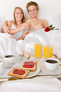 Luxury hotel honeymoon breakfast - couple in bed