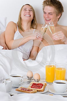 Luxury hotel honeymoon breakfast - couple in bed