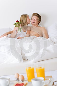 Luxury hotel honeymoon breakfast - couple in bed