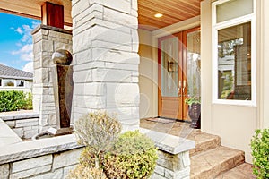 Luxury house entrance porch with stone column trim and stained w