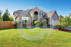 Luxury house exterior with brick and siding trim and double garage.