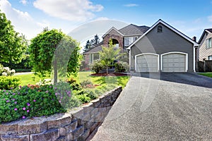 Luxury house exterior with brick and siding trim and double garage.