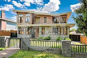 Luxury house with metal fence in front and concrete pathway to the entrance