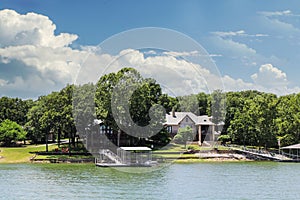 Luxury houses built beside lake with docks and little beaches among the trees