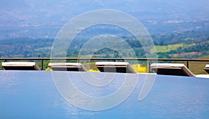 Luxury infinity pool and lounge chairs at Costa Rican premium travel hotel poolside.