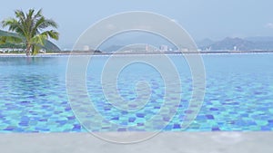 Luxury infinity pool in resort hotel on blue sea and city panorama background. Swimming pool in luxury hotel with view