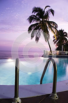 Luxury infinity swimming pool caribbean sunset