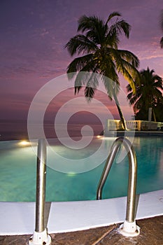 Luxury infinity swimming pool caribbean sunset