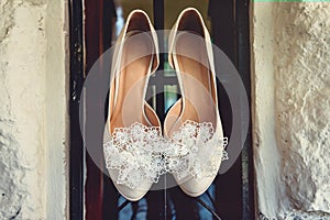 Luxury ivory wedding shoes with lace flower on it, for bride, selective focus. photo