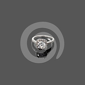 Luxury jewellery. White gold or silver ring isolated on gray background. Selective focus.