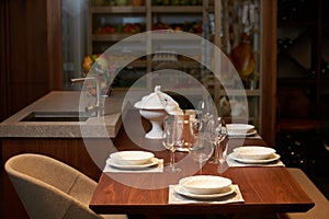 Modern kitchen interior with clean white plates, glasses and cut