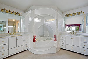 Luxury large white master bathroom cabinets with double sinks and big bath tub.