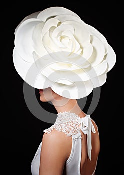 Luxury lifestyle, vogue and style concept-portrait of stylish young lady with big white rose on the head, isolated on black