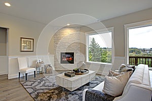 Luxury living room features corner stone fireplace